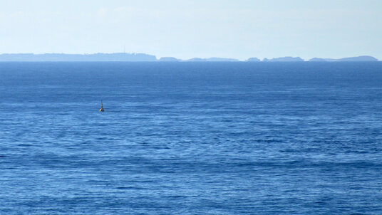 Seven Stones buoy with the Scilly Isles in the background
